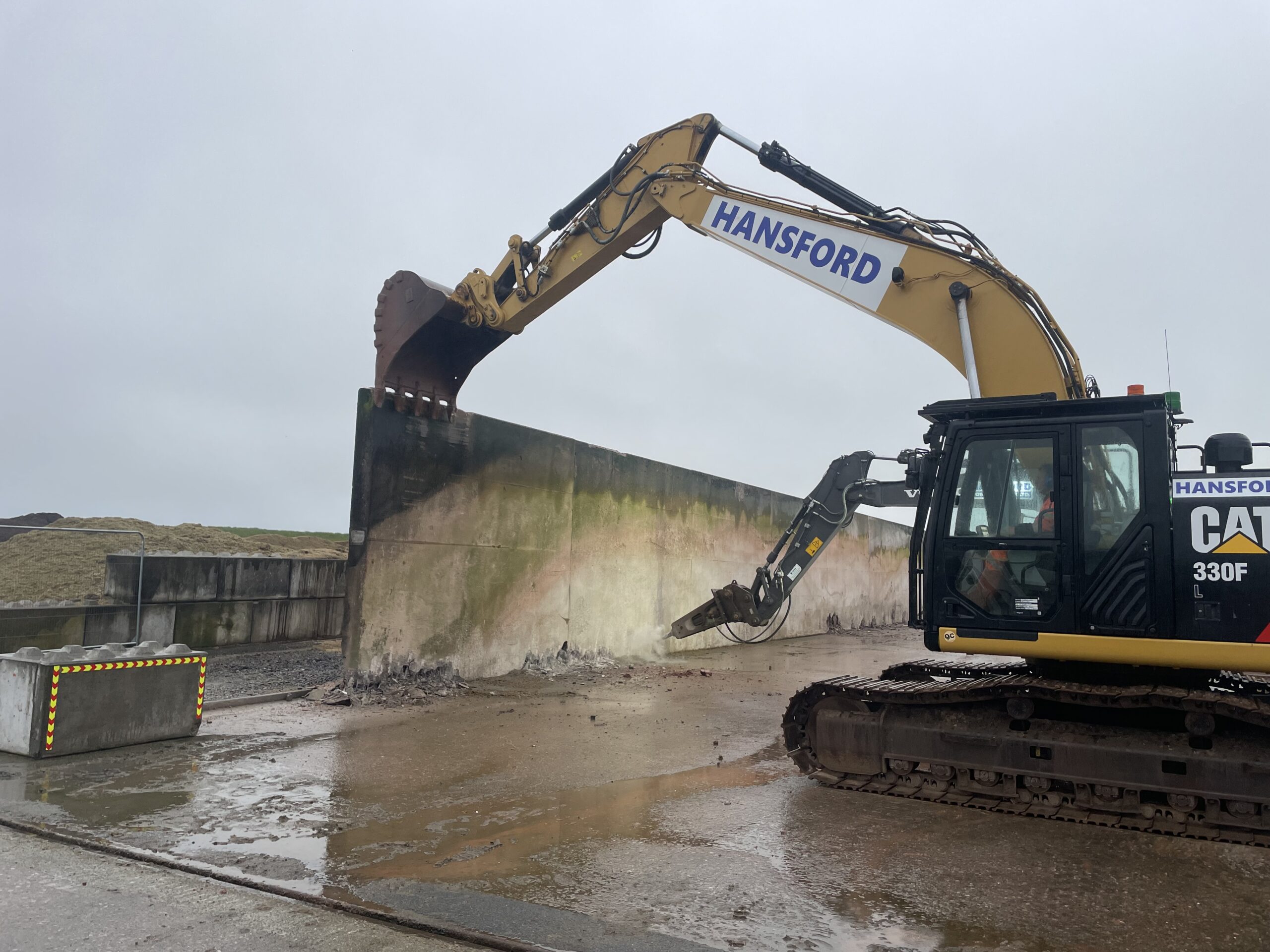 Excavator loading aggregate during silage clamp reconstruction in North Devon