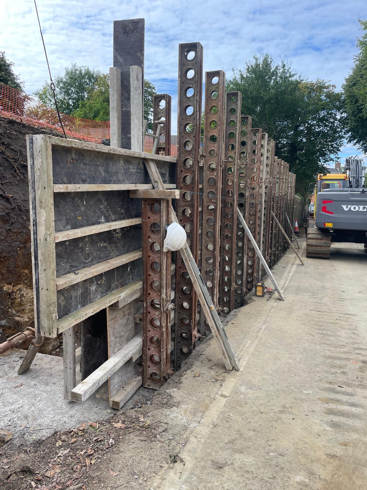 Steel reinforcement and shuttering installed for new retaining wall construction.