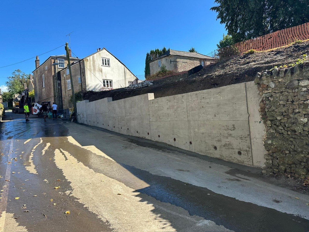 Roadside excavation and groundworks for retaining wall replacement.